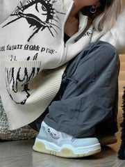 Strickjacke mit großen Taschen und unterschiedlichem Aufdruck