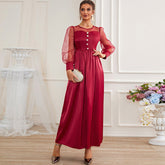 Vestido tipo A de gasa blanca con cuello redondo y cierre decorativo de cintura alta en color rojo.