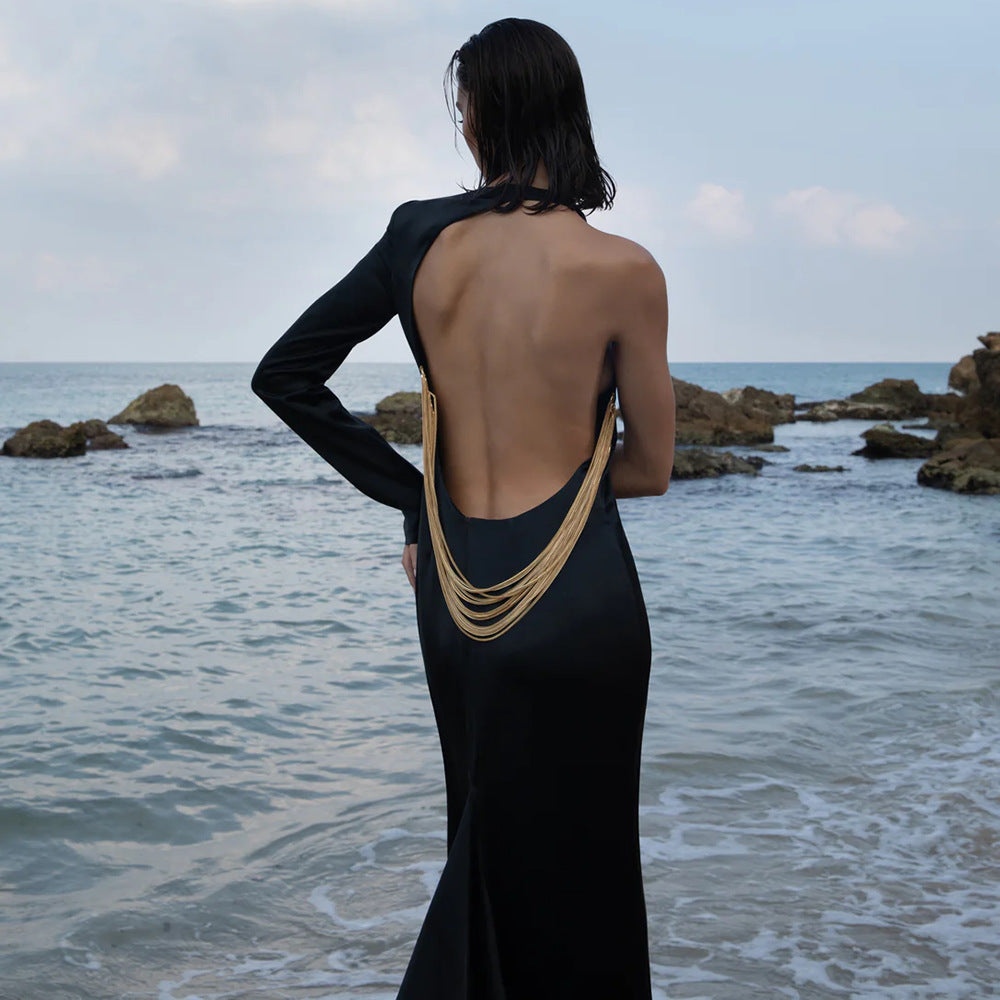 Vestido largo negro con un hombro descubierto y cadena de serpiente