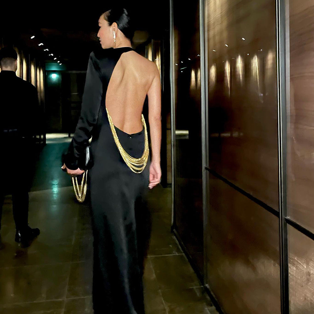 Vestido largo negro con un hombro descubierto y cadena de serpiente
