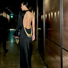 Vestido largo negro con un hombro descubierto y cadena de serpiente